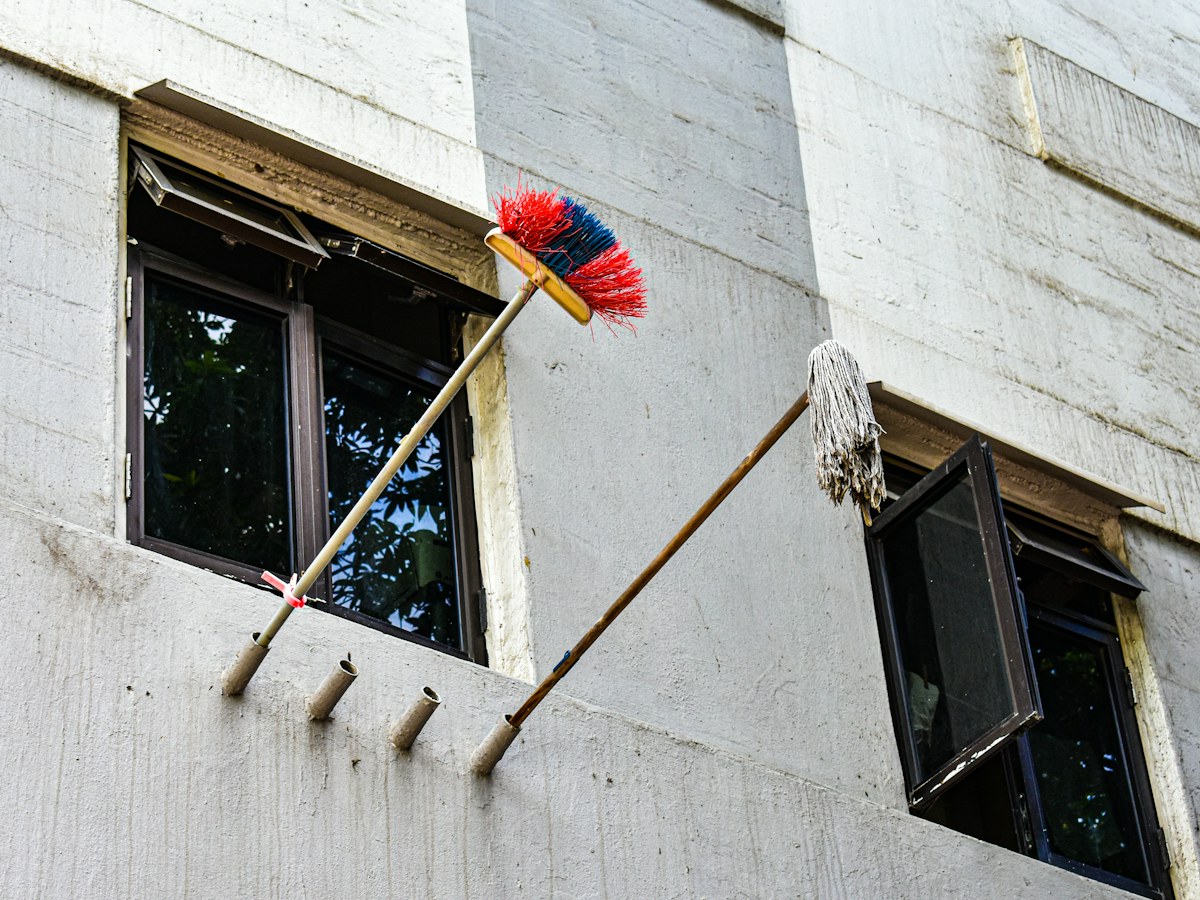 Broom and mop cleaning exterior building windows